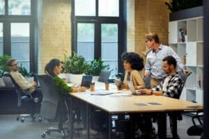 Office life. Group of young multiracial people sitting at the table in coworking space and working